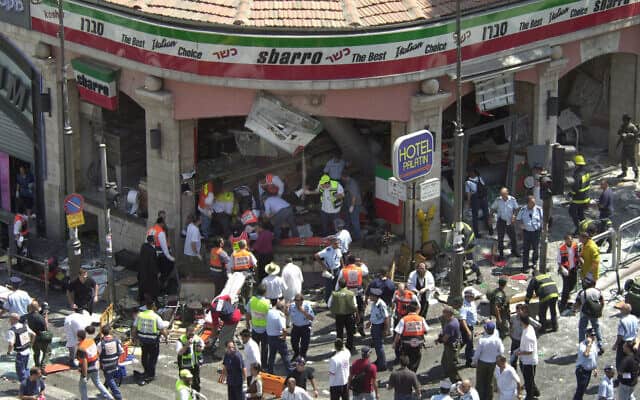 שוטרים ופרמדיקים מקיפים את זירת פיגוע ההתאבדות במסעדת סבארו בירושלים, 9 באוגוסט 2001. בפיגוע נהרגו 15 בני אדם ונפצעו 130 (צילום: AP/ פיטר דיונג)