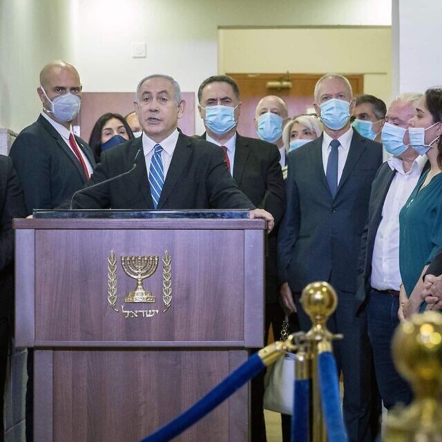 חברי הליכוד עומדים סביב בנימין נתניהו בבית המשפט המחוזי בירושלים, לפני פתיחת משפטו, ב-24 במאי 2020 (צילום: יונתן זינדל/פלאש90)