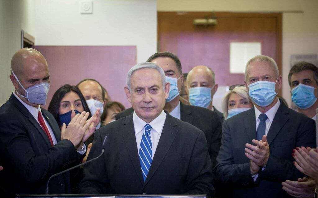 חברי הליכוד עומדים סביב בנימין נתניהו בבית המשפט המחוזי בירושלים, לפני פתיחת משפטו, 24 במאי 2020 (צילום: יונתן זינדל, פלאש90)