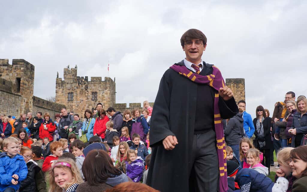 אילוסטרציה, שחקן שמגלם את הארי פוטר מדריך סיור מאורגן בטירה באנגליה ששימשה לצילומי כמה מהסרטים בסדרה (צילום: istockphoto/mikeuk)