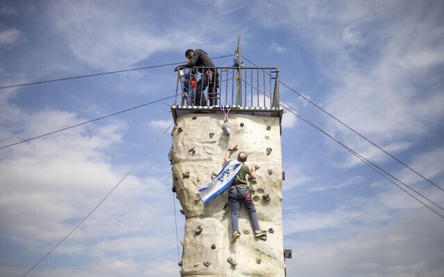 צעיר מנסה להניף את דגל ישראל בבקעת הירדן, פברואר 2020 (צילום: AP Photo/Ariel Schalit)