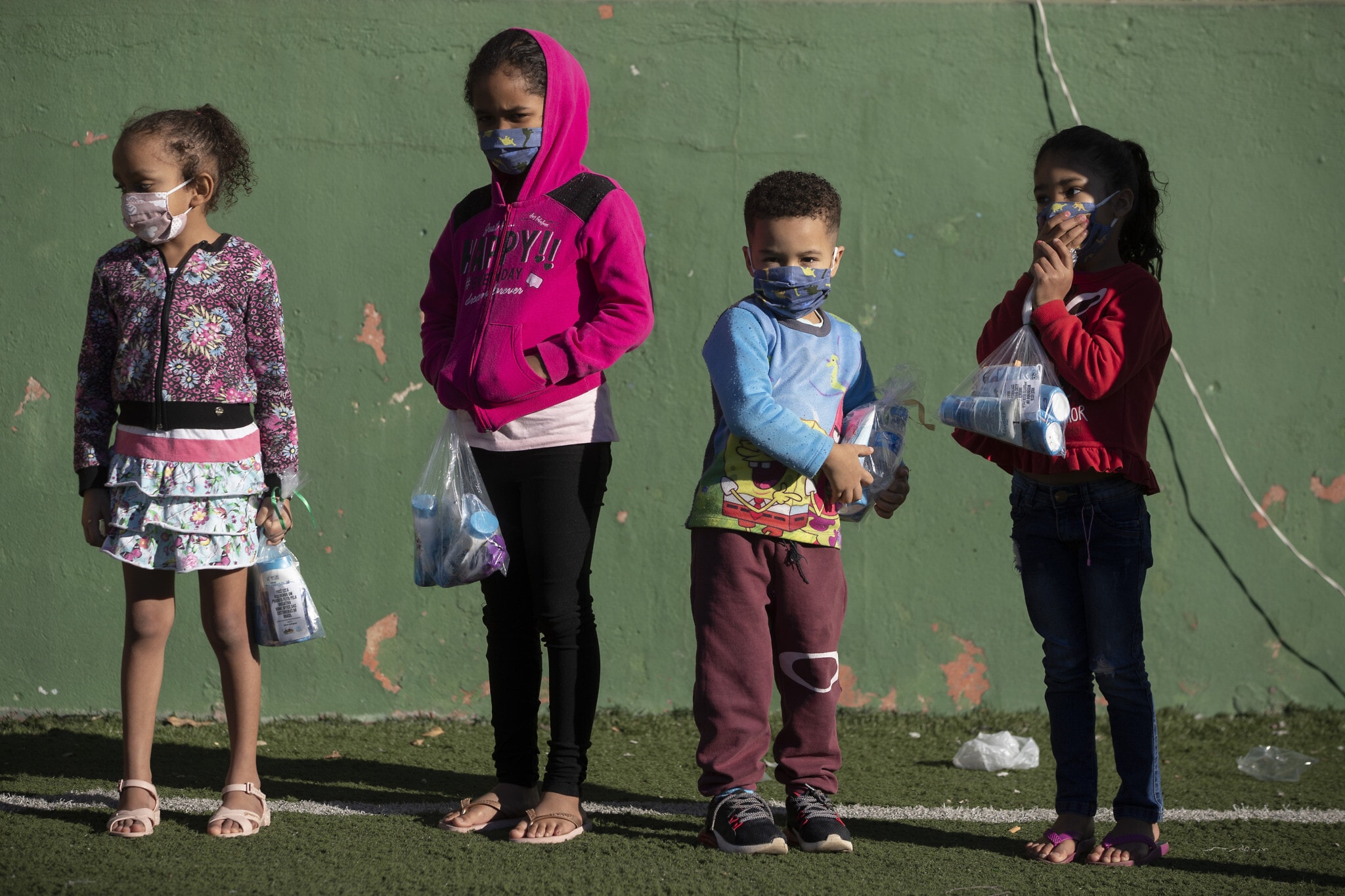 ילדים ברזילאים שקיבלו ציוד אישי למאבק במגפה, יוני 2020 (צילום: AP Photo/Andre Penner)