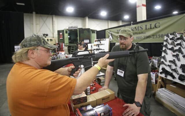 שרדן בודק רובה ציד Akdal 1919 בסגנון AR-15 באחד הדוכנים בתערוכת PrepperCon בסנדי, יוטה, 24 באפריל 2015 (צילום: AP/ריק באומר)