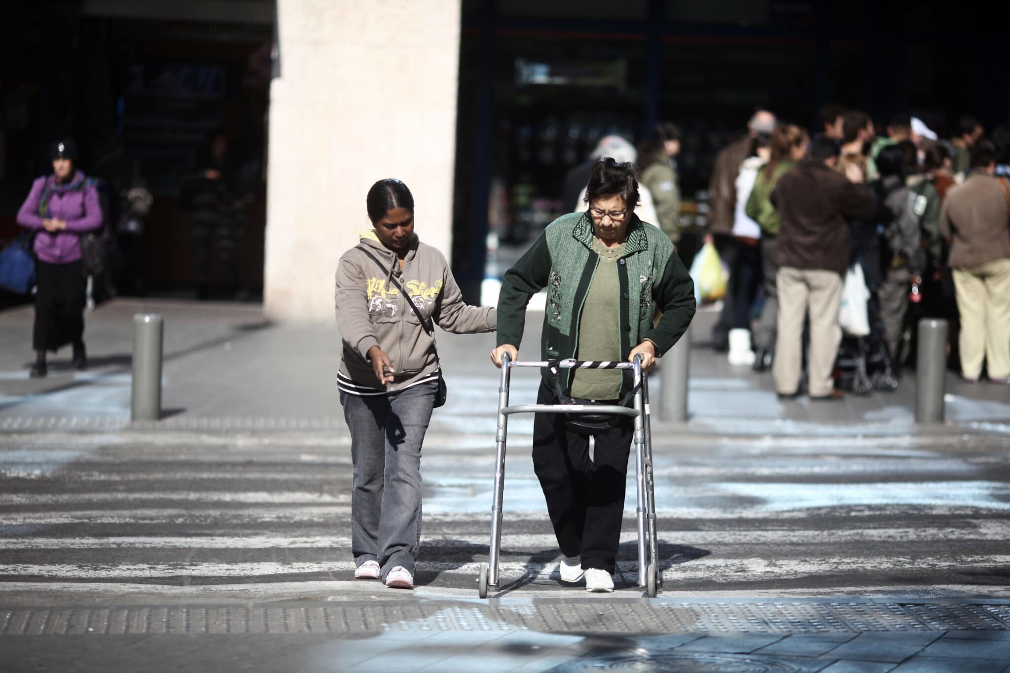 אילוסטרציה: מטפלת פיליפינית מסייעת לקשישה לחצות את הכביש ליד התחנה המרכזית בירושלים. למצולמים אין קשר לנאמר בכתבה (צילום: קובי גדעון/פלאש90)