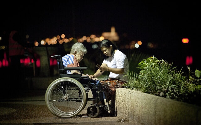מטפלת פיליפינית וקשישה בטיילת בתל אביב. למצולמים אין קשר לנאמר בכתבה (צילום: משה שי/פלאש90)