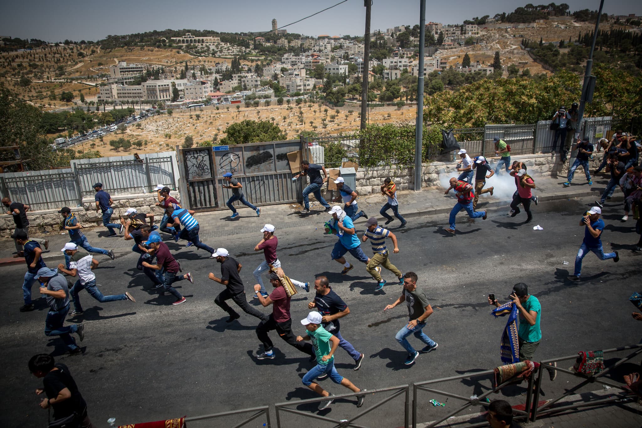 פלסטינים נמלטים מגז מדמיע שפיזרה המשטרה בוואדי ג'וז, ארכיון, 2018 (צילום: Miriam Alster/Flash90)