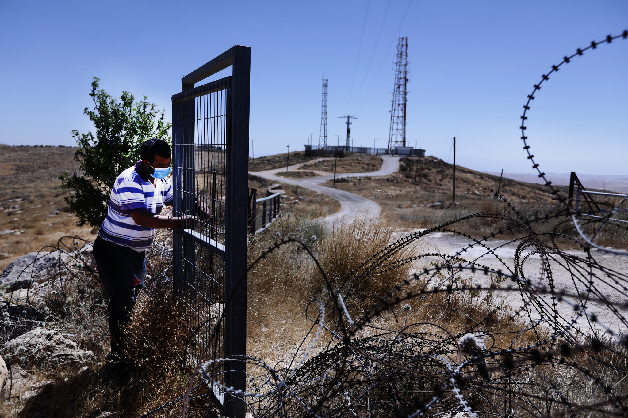 עתמאן אבו קביטה ליד השער שהציב צה&quot;ל באמצע השטח שלו (צילום: אלדד רפאלי)