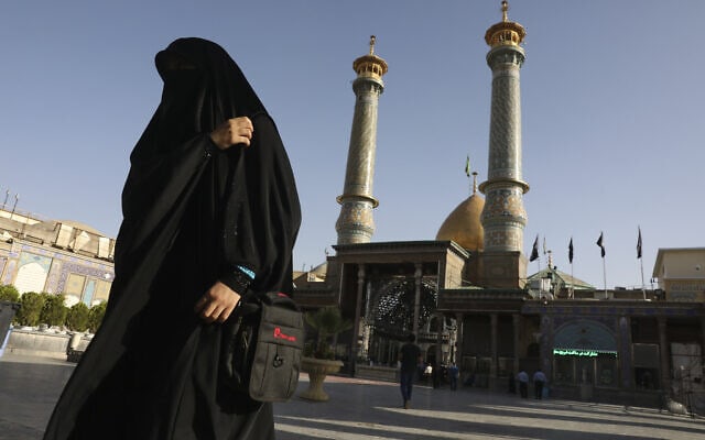 אישה איראנית חולפת ליד מסגד שנסגר בשל מגבלות הקורונה, יוני 2020 (צילום: AP Photo/Vahid Salemi)