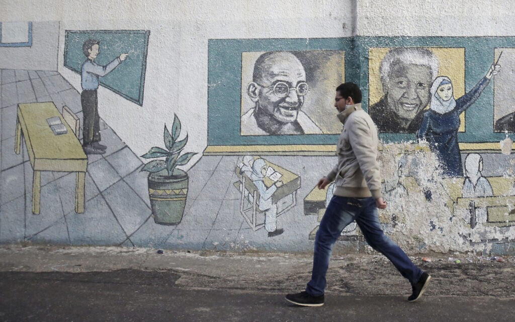 פלסטיני על רקע ציור קיר של נלסון מנדלה ומהטמה גנדי, 2013 (צילום: AP Photo/Adel Hana)