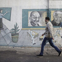 פלסטיני על רקע ציור קיר של נלסון מנדלה ומהטמה גנדי, 2013 (צילום: AP Photo/Adel Hana)