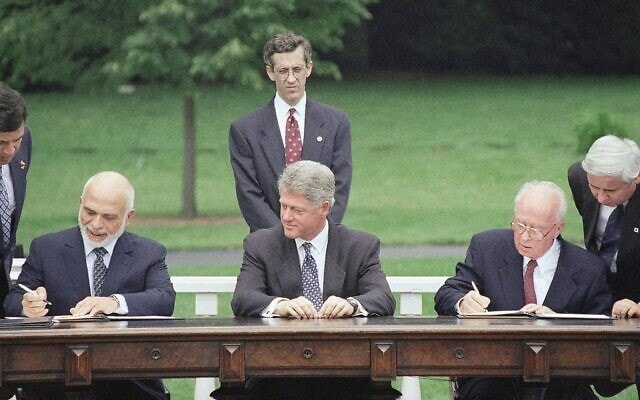 נשיא ארצות הברית ביל קלינטון מביט במלך חוסיין ובראש הממשלה יצחק רבין חותמים על הצהרה ששמה קץ ל-46 שנים של פעולות איבה בין המדינות, במדשאה הדרומית בבית הלבן בוושינגטון, 25 ביולי 1994 (צילום: AP/מרסי נייטסוונדר)