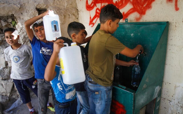 ילדים פלסטינים ממלאים מים בג&#039;ריקנים (צילום: Nasser Ishtayeh/Flash90)