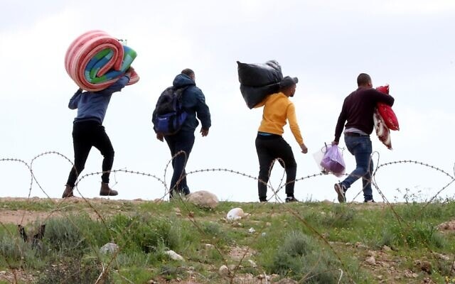 פועלים פלסטינים נכנסים לישראל דרך חור בגדר, לאחר שכניסתם נאסרה בגלל הקורונה, 22 במרץ 2020 (צילום: Wisam Hashlamoun/Flash90)