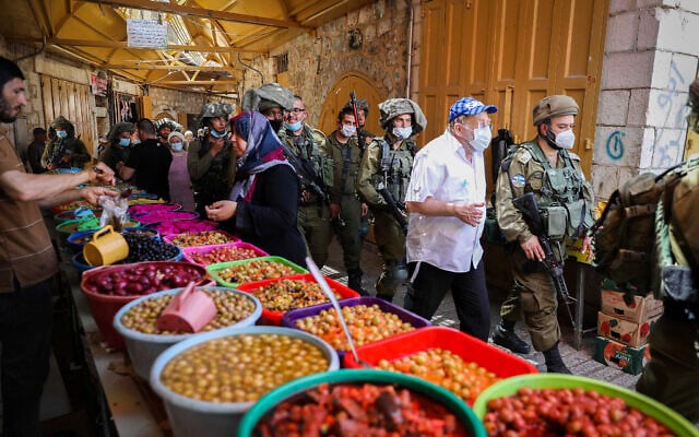חיילים רבים מלווים סיור של מבקרים יהודים בחברון, 16 במאי 2020 (צילום: Wisam Hashlamoun/Flash90)