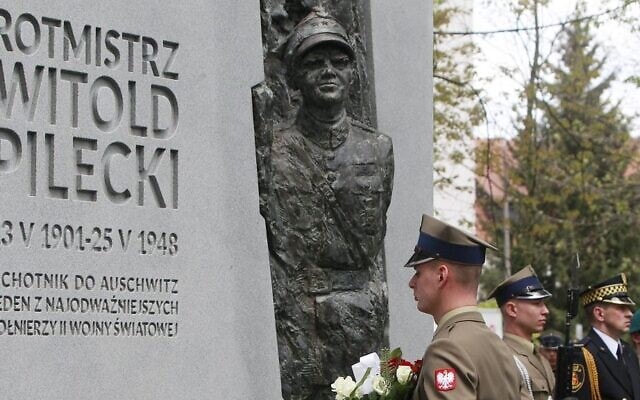 חייל מניח פרחים על אנדרטה לזכרו של גיבור מלחמת העולם השנייה קפטן ויטולד פילצקי, שנכנס לאושוויץ מרצונו כדי לדווח על הזוועות המתחוללות שם, ומאוחר יותר הוצא להורג על ידי המשטר הקומוניסטי הפולני, במהלך טקס הסרת הלוט מעל האנדרטה בוורשה, פולין, 13 במאי 2017 (צילום: AP/צ&#039;ארק סוקולובסקי)