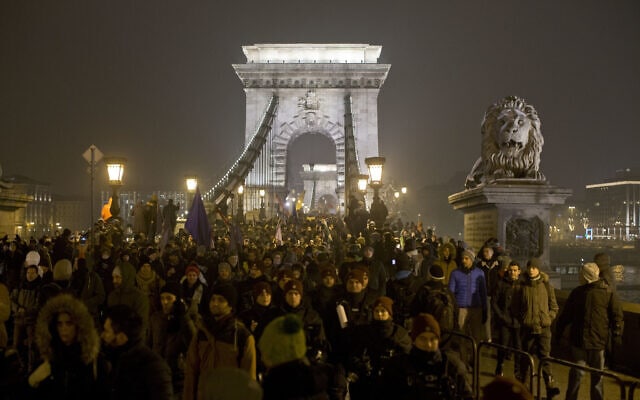 מפגינים צועדים לאורך גשר השרשרת של בודפשט במהלך צעדה נגד ממשלתו הלאומנית של ראש הממשלה ויקטור אורבן. דצמבר 2018 (צילום: (AP Photo/Marko Drobnjakovic)
