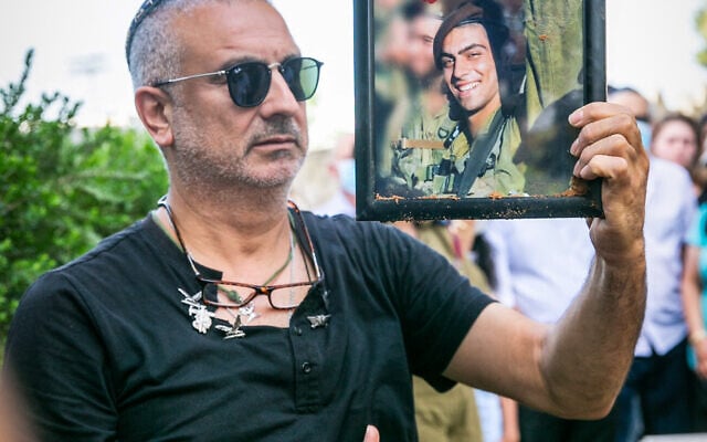 אביו של עמית בן יגאל אוחז בתמונת בנו המובא למנוחות, מאי 2020 (צילום: פלאש 90)
