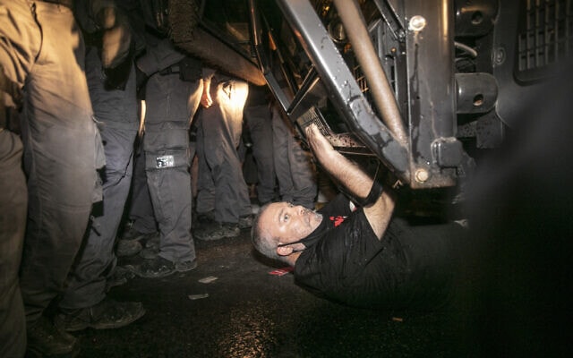 גונן בן יצחק נשכב מתחת למכתז&quot;ית בהפגנה בבלפור (צילום: אוליבייה פיטוסי/פלאש 90)