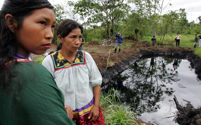 נשים עומדות ליד בריכת נפט באזור האמזונס של אקוודור, 20 באוקטובר 2005 (צילום: AP Photo/Dolores Ochoa)