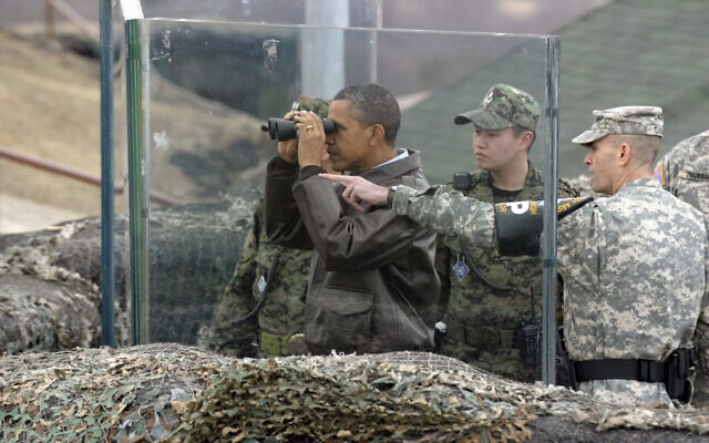 מרץ 2012: הנשיא ברק אובמה מביט במשקפת על קוריאה הצפונית מהאזור המפורז בין שתי הקוריאות (צילום: AP Photo/Susan Walsh, File)