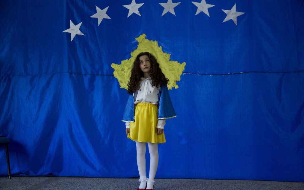 סופי בת העשר מתייצבת לפני דגל קוסובו במהלך טקס חגיגת יום העצמאות העשירי של קוסובו בבית ספרה, 2018. סופי הייתה הילדה הראשונה שנולדה בקוסובו העצמאית (צילום: AP Photo/Visar Kryeziu)