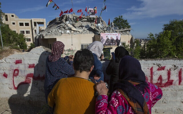 אילוסטרציה, נשים פלסטיניות מסתכלות על בית מחבל שנהרס בחלקו על ידי צה&quot;ל בכפר קובאר ליד רמאללה, 11 במאי 2020 (צילום: AP Photo/Nasser Nasser)