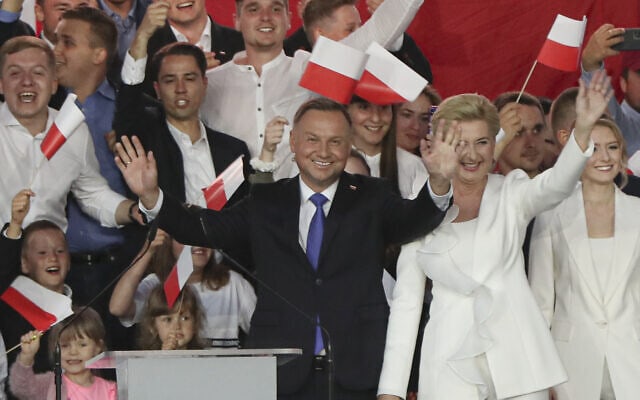 נשיא פולין המכהן אנדז&#039;יי דודה, משמאל, ורעייתו אגתה קורנהאוזר-דודה מנופפים לתומכים בפולטוסק, פולין, 12 ביולי 2020 (צילום: AP/צ&#039;ארק סוקולובסקי)