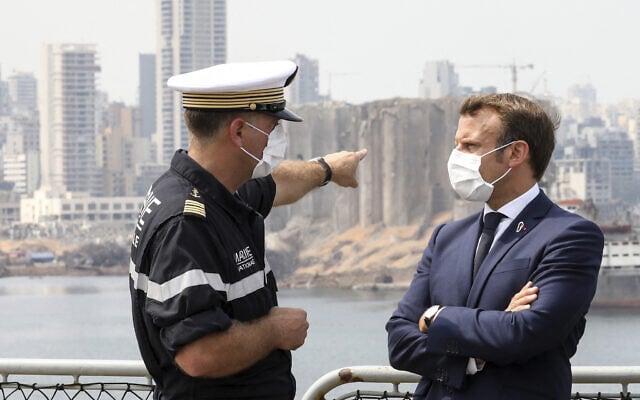 נשיא צרפת עמנואל מקרון מחוץ לנמל ביירות, יום שלישי, 1 בספטמבר 2020. לשמאלו, קצין חיל הים הצרפתי (צילום: סטפן למוטון דרך AP)
