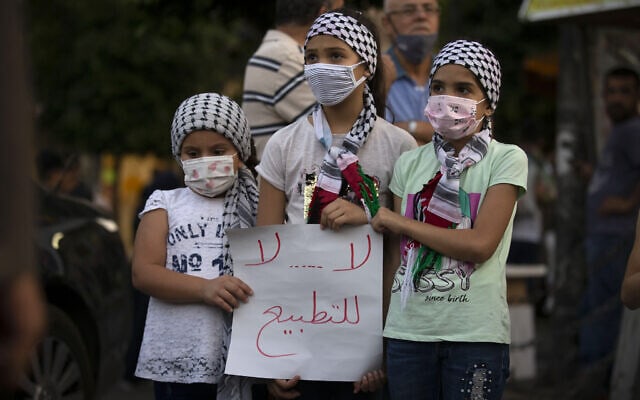 ילדות פלסטיניות ברמאללה מחזיקות שלט שעליו כתוב &quot;לא, לא, לנורמליזציה&quot; במהלך מחאה נגד ההסכם עם איחוד האמירויות ובחריין עם ישראל, 15 בספטמבר 2020 (צילום: AP Photo/Majdi Mohammed)