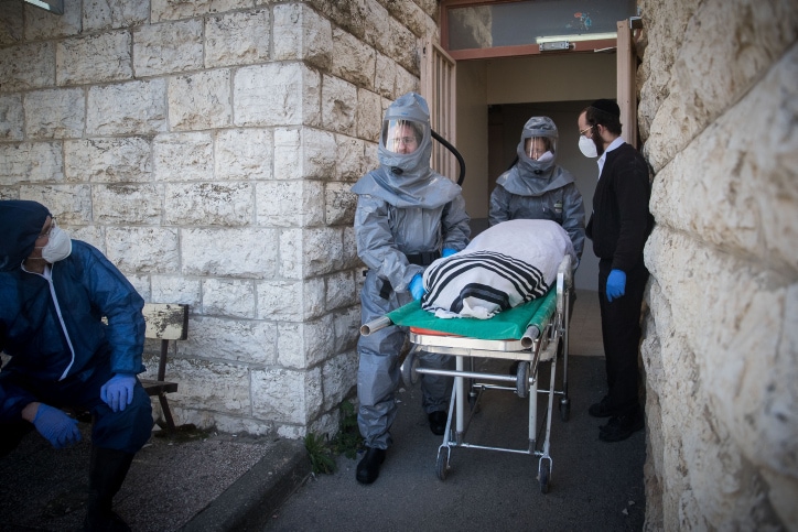 עובדי חברה קדישא נושאים גופה של חולה שמת מקורונה בירושלים, 29 במרץ 2020 (צילום: יונתן זינדל, פלאש 90)