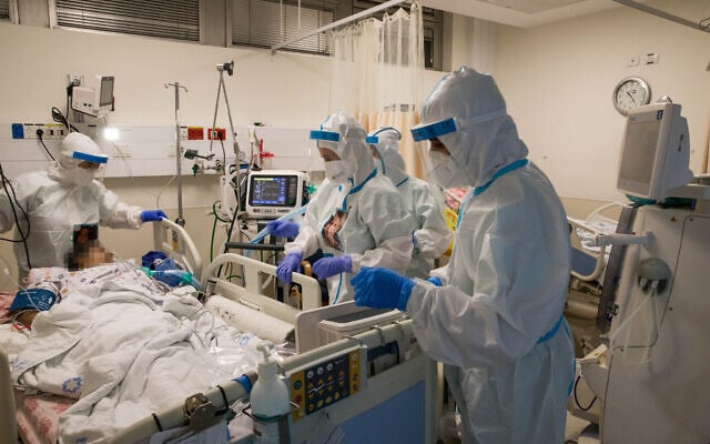 אנשי צוות רפואי מטפלים בחולה קורונה כשהם לובשים בגדי מגן. 23 בספטמבר 2020. (צילום: Nati Shohat/Flash90)