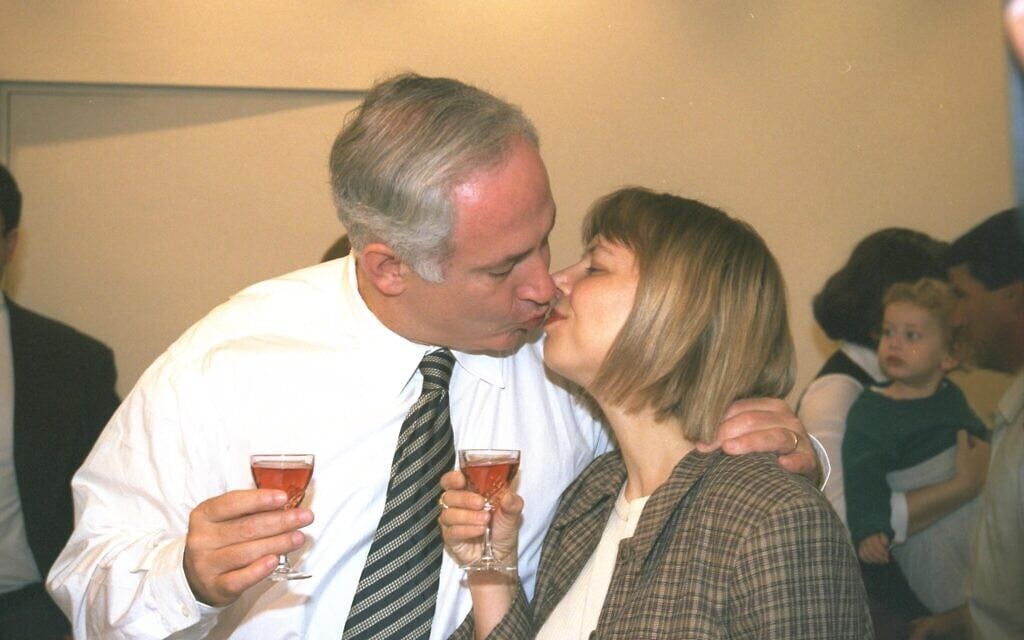ראש הממשלה בנימים נתניהו נושק לרעייתו שרה, במסיבת הפתעה אשר נערכה לכבוד יום הולדתו ה-47 במשרדו בירושלים, ב-21 באוקטובר 1996 (צילום: יעקב סער/לע"מ)