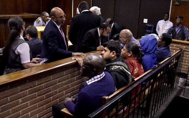 בתמונה זו, מ-15 בפברואר 2018, שמונה חשודים, בהם בן משפחת גופטה, יושבים על ספסל הנאשמים בבית משפט אזורי בבלומפונטיין, דרום אפריקה, במסגרת חקירה סביב מעילה לכאורה בכספי מדינה שיועדו לפרויקט חליבה (צילום: AP Photo)