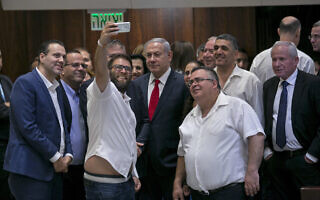 אורן חזן מצטלם בסלפי עם ראש הממשלה בנימין נתניהו ושרי הליכוד, אחרי העברת חוק הלאום, 19 ביולי 2018 (צילום: AP Photo/Olivier Fitoussi) אורן חזן מצטלם בסלפי עם ראש הממשלה בנימין נתניהו ושרי הליכוד, אחרי העברת חוק הלאום, 19 ביולי 2018 (צילום: AP Photo/Olivier Fitoussi)