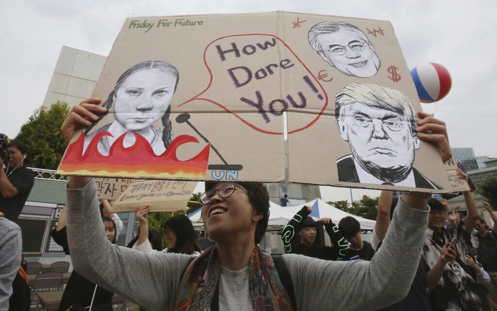פעילים ירוקים בקוריאה הדרומית עם כרזה שבה גרטה תונברג נוזפת בדונלד טראמפ, 2019 (צילום: AP Photo/Ahn Young-joon)