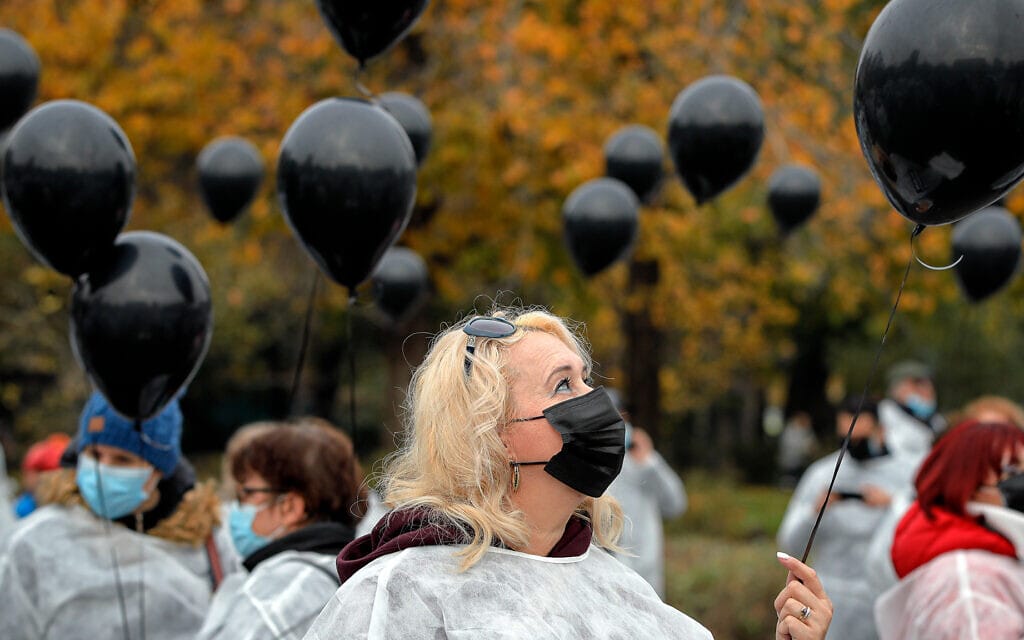 אנשי הצוות הרפואי ברומניה משחררים בלונים שחורים לזכרם של המתים במגפת הקורונה, 17 בנובמבר 2020 (צילום: AP Photo/Vadim Ghirda)