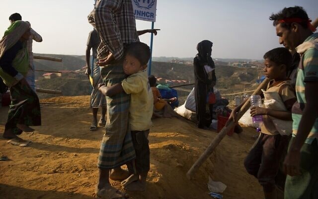 ילד פליט רוהינגי ששהה בשטח הפקר בבנדרבן, בין מיאנמר לגבול בנגלדש, נצמד לאביו עם הגיעם למחנה הפליטים בלוחאלי, 50 ק&quot;מ מקוקס באזר, בנגלדש, 24 בינואר 2018 (צילום: צילום: AP Photo/Manish Swarup)