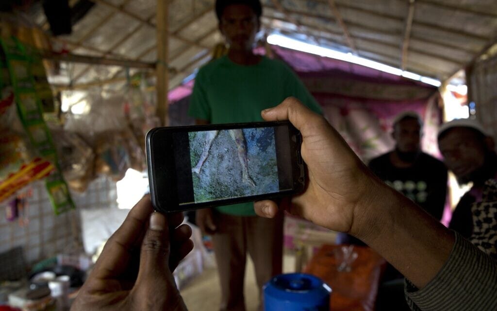 ילד פליט רוהינגי ששהה בשטח הפקר בבנדרבן, בין מיאנמר לגבול בנגלדש, נצמד לאביו עם הגיעם למחנה הפליטים בלוחאלי, 50 ק"מ מקוקס באזר, בנגלדש, 24 בינואר 2018 (צילום: AP Photo/Manish Swarup)