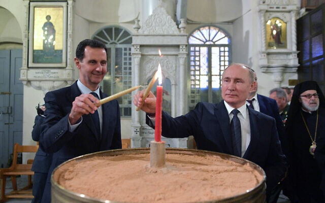 נשיא רוסיה ולדימיר פוטין ונשיא סוריה בשאר אסד מדליקים נרות בקתדרלה הנוצרית האורתודוקסית בדמשק, 7 בינואר 2020 (צילום: Alexei Druzhinin, Sputnik, Kremlin Pool Photo via AP)