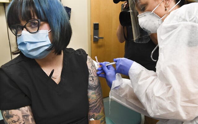 מתנדבת מקבלת חיסון נגד קורונה של חברת מודרנה. יולי 2020 (צילום: AP Photo/Hans Pennink)