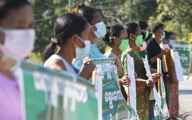 המפגינים מחזיקים כרזות מחוץ למשרד ועדת הבחירות, בנאפיטאו, מיאנמר. מפלגת האופוזיציה הראשית שנתמכה על ידי הצבא הודיעה כי אינה מכירה בבחירות שנערכו במיאנמר, ודחתה את התוצאות. נובמבר 2020 (צילום: AP Photo/Aung Shine Oo)