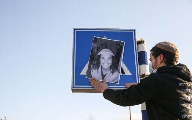 מוחה תולה על תמרור בצפת את תמונתו של אהוביה סנדק שנהרג בעת מרדף משטרתי, 22 בדצמבר 2020 (צילום: דוד כהן, פלאש 90)