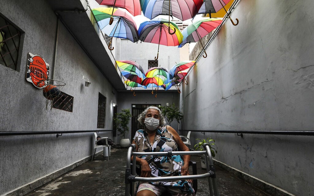 אישה ממתינה להתחסן בבית מחסה ציבורי בסאו פאולו, ברזיל. 19 בינואר 2021 (צילום: AP Photo/Marcelo Chello)