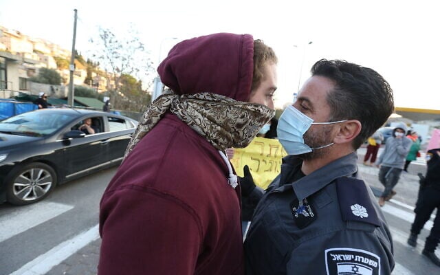 שוטר ומפגין מתעמתים במחאה על מותו של אהוביה סנדק בצפת, 22 בדצמבר 2020 (צילום: דוד כהן/פלאש90)