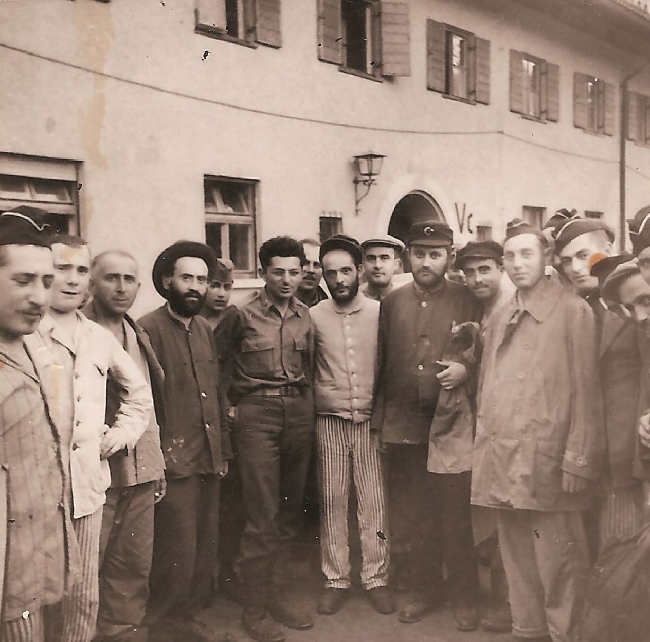 הרב אברהם קלאוזנר, ללא כובע במרכז-שמאל, עם הניצולים במחנה הפליטים (צילום: באדיבות עמוס קלאוזנר)