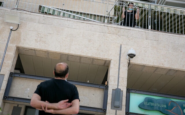 גבר מדבר עם אמו כשהיא על המרפסת בבית אבות בירושלים, 22 באפריל 2020 (צילום: אליבייה פיטוסי/פלאש90)