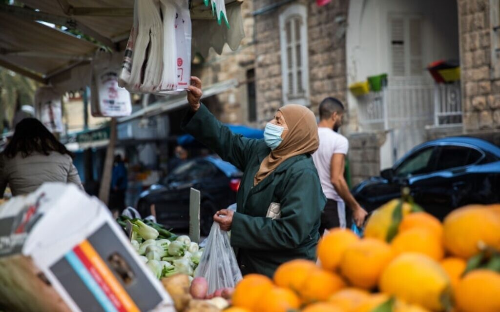 אישה עושה קניות בוואדי ניסנאס בחיפה, 5 בפברואר 2021 (צילום: Shir Torem/Flash90)