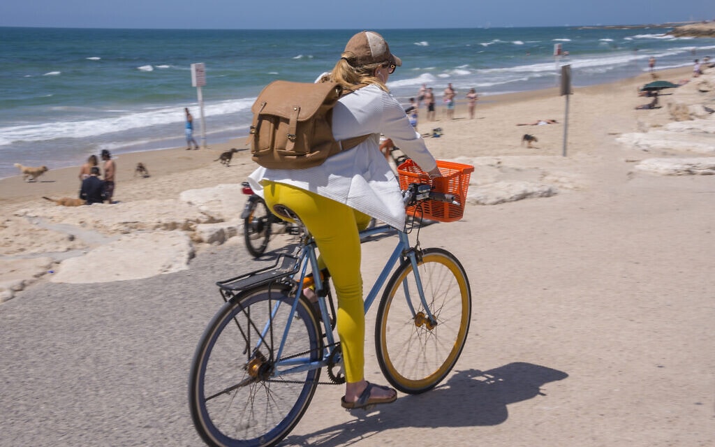 אישה רוכבת על אופניים בטיילת בתל אביב. אילוסטרציה (צילום: iStock)