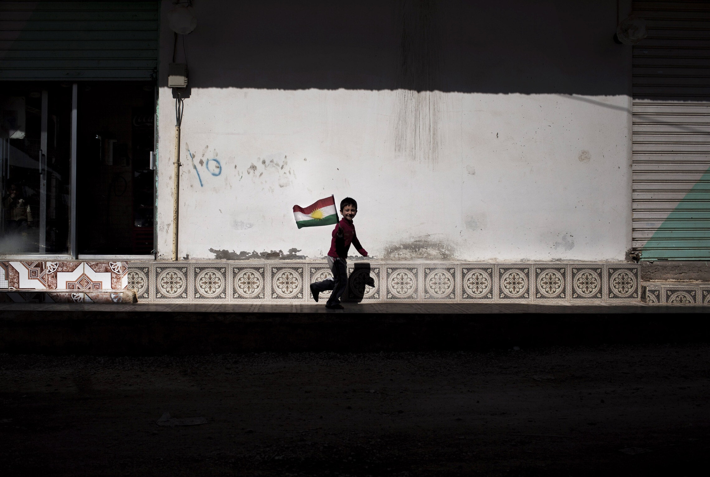 נער כורדי רץ בין חורבות ראס אל-עין, פברואר 2013 (צילום: AP Photo/Manu Brabo)
