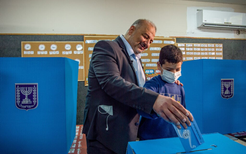 מנהיג רע"ם מנסור עבאס מצביע בבחירות יחד עם בנו, 23 במרץ 2021 (צילום: Flash90)